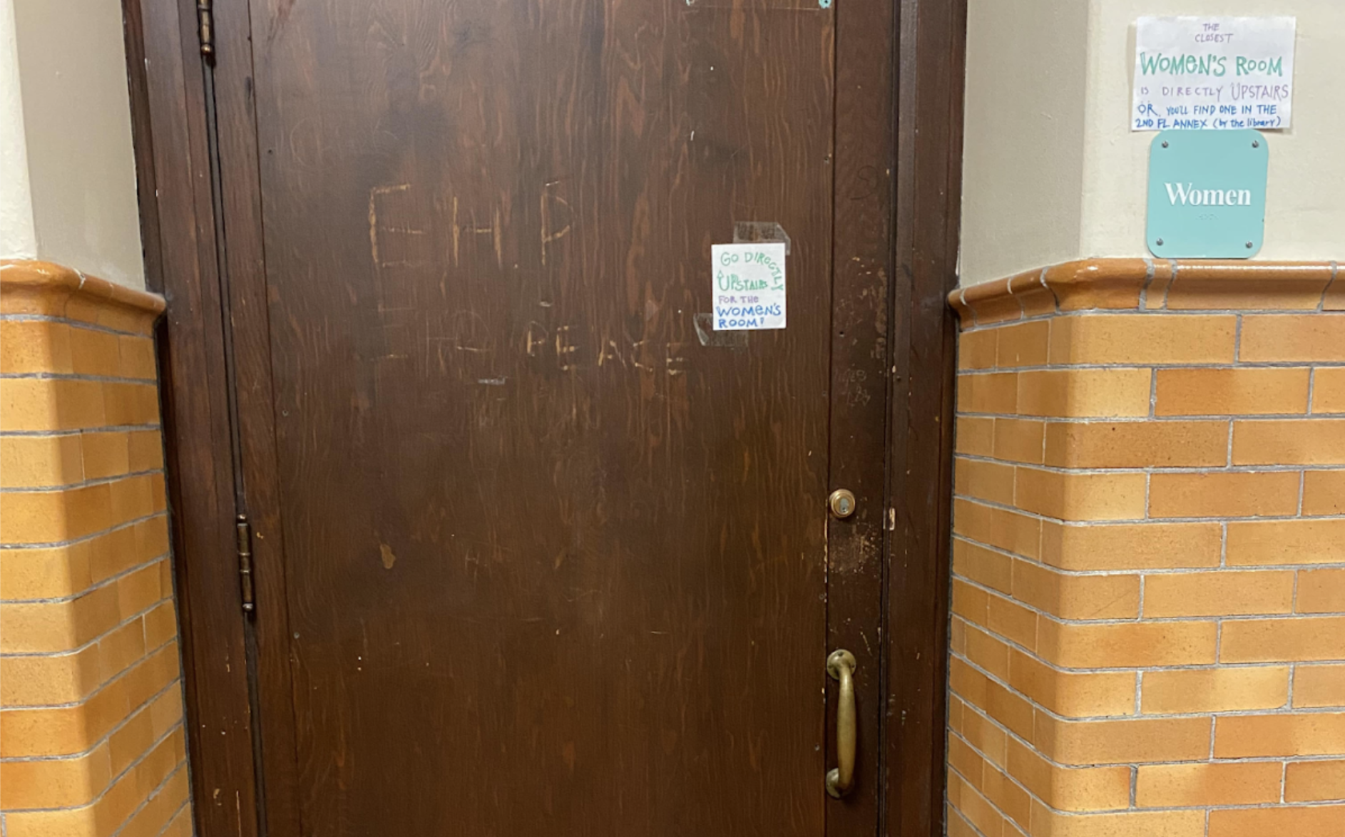 The locked door of the second-floor main Womens restroom with a sign that reads: The closest womens room is directly upstairs or youll find one in the 2nd fl. annex.